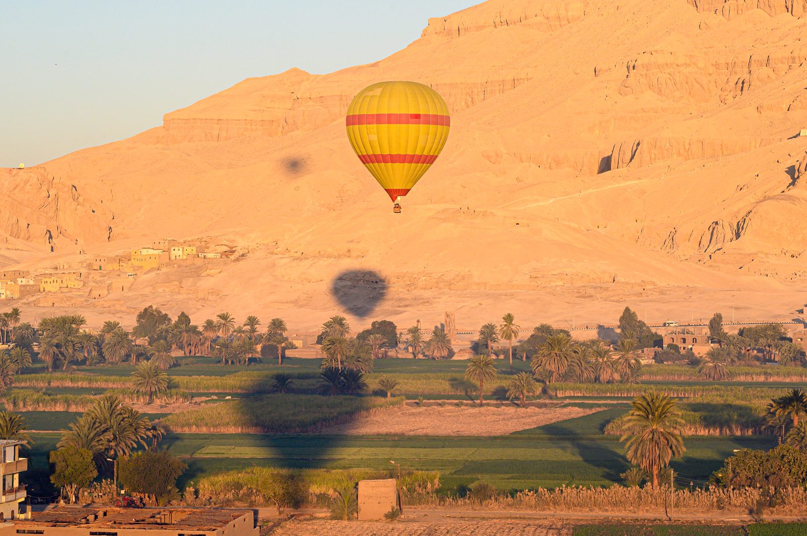 بالون فوق حقول البر الغربي في الأقصر وجبل الدير البحري خلفه